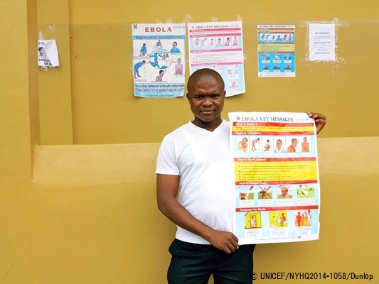 エボラの症状が描かれたポスターを見せる、ケネマ地区の病院で働く薬剤師。（シエラレオネ）© UNICEF/NYHQ2014-1058/Dunlop