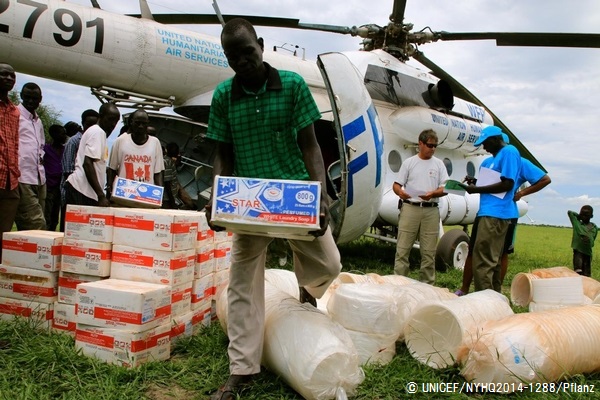 上ナイル州のKiech Kuonに空輸された栄養補助食をヘリコプターから運び出すスタッフ。© UNICEF/NYHQ2014-1288/Pflanz