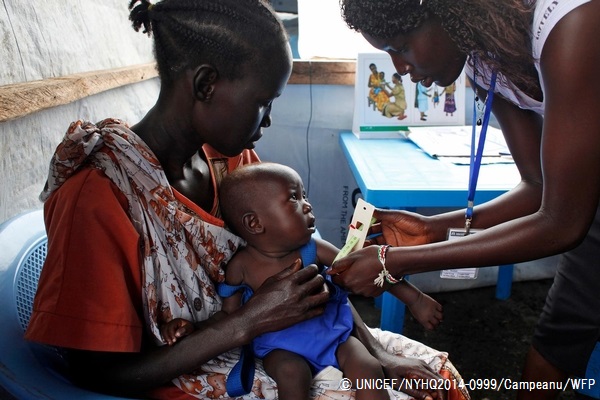 上腕の周囲を測り、栄養状態の検査を行う様子。© UNICEF/NYHQ2014-0999/Campeanu/WFP