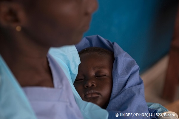 エボラの感染が疑われる人たちが身を寄せるセンターで、抱かれて眠る1歳の赤ちゃん。エボラの症状は出ていないものの、両親をエボラで失い、親せきを探している。© UNICEF/NYHQ2014-1823/Bindra