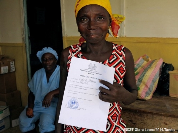 エボラ治療センターから退院し、エボラから回復したという証明書を見せる女性。© UNICEF Sierra Leone/2014/Dunlop
