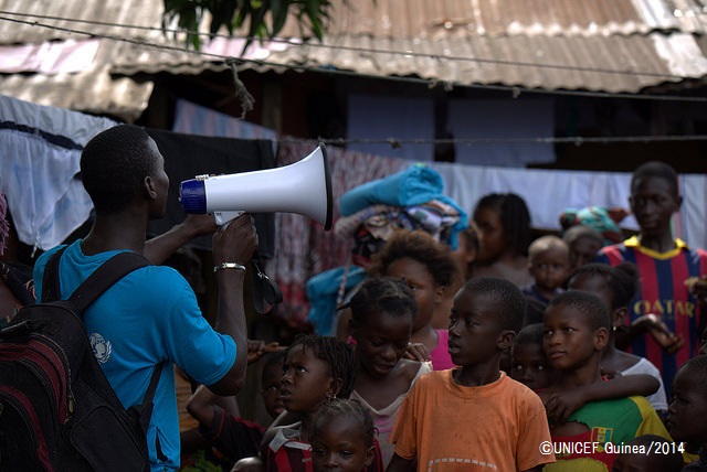 町を訪れ、エボラの予防法を子どもたちに説明するスタッフ。（ギニア）©UNICEF Guinea/2014
