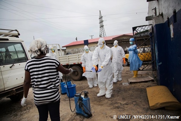 エボラ患者の遺体の搬送を担う保健員たち。防護服を身につけ、消毒を行う様子。© UNICEF/NYHQ2014-1791/Kesner