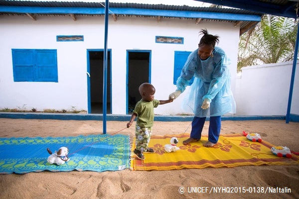 ユニセフが支援する一時ケアセンターで、母親をエボラで失った1歳半の男の子と遊ぶスタッフ。（ギニア）© UNICEF_NYHQ2015-0138_Naftalin