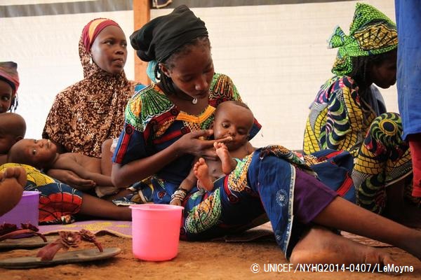 栄養不良に陥った子どもにすぐ口にできる栄養治療食を与える母親。© UNICEF_NYHQ2014-0407_LeMoyne