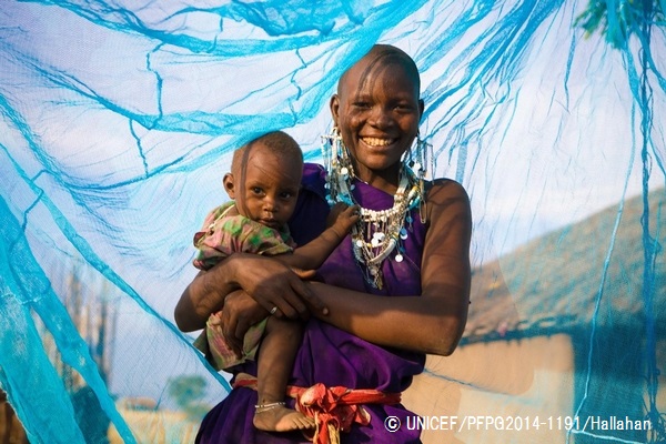 蚊帳の中で笑顔を見せる親子（タンザニア）。© UNICEF_PFPG2014-1191_Hallahan