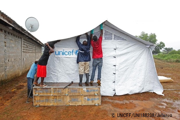 マルギビ郡でのエボラの新たな感染を受け、ユニセフは迅速に緊急支援物資を輸送。雨の中、エボラ対応用のテントを建てるスタッフ。© UNICEF_UNI188238_Jallanzo