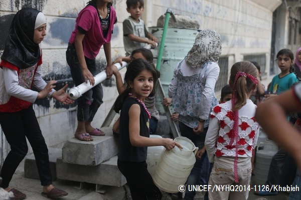 給水タンクを持って、水を汲むための順番を待つ子ども。（2014年撮影）© UNICEF_NYHQ2014-1126_Khabieh