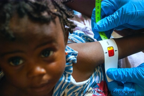 ユニセフが支援する保健センターで栄養状態の検査をする女の子。赤色は栄養不良の可能性がある危険な状態。© UNICEF_NYHQ2015-0135_Naftalin