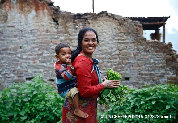 3歳の子どもをおんぶして野菜を収穫する女性。（ネパール）© UNICEF_PFPG2015-3428_Shrestha