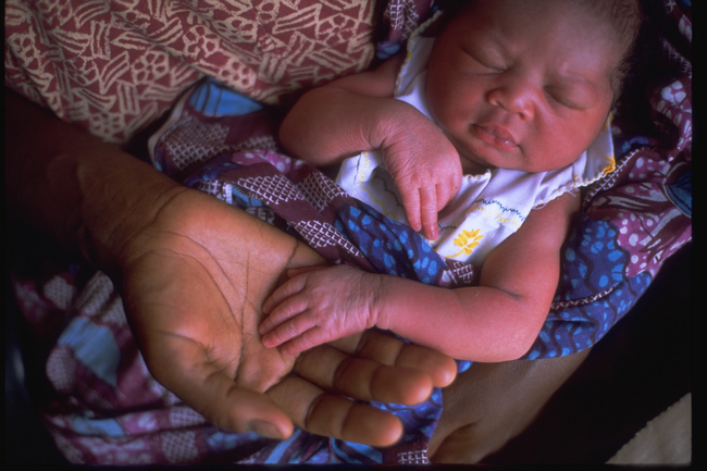 お母さんの腕の中で眠る生まれたばかりの赤ちゃん（ガーナ）(c) UNICEF/NYHQ2002-0570/GIACOMO PIROZZI