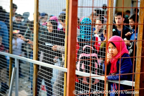 難民一時受け入れセンターの近くのフェンスの前で電車を待つアフガニスタンの少女。（マケドニア旧ユーゴスラビア共和国）© UNICEF_MCDA2015-00019_Georgiev
