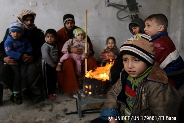 ガザ地区の破壊された自宅で、家族と一緒に焚火の周りに集まって暖を取る子どもたち。© UNICEF_UNI179861_El Baba