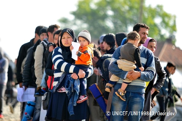 子どもを抱え、難民一時受け入れ所へ入る列に並ぶ人々。（マケドニア旧ユーゴスラビア共和国）© UNICEF_UNI199843_Georgiev