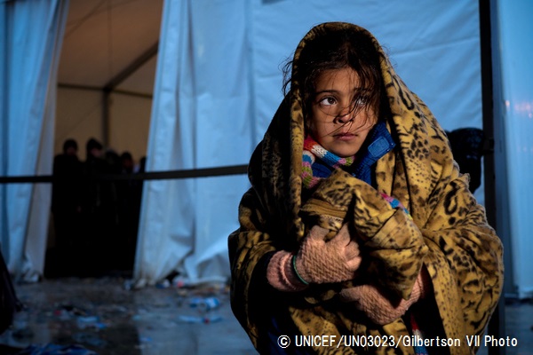 一時受け入れ所のテントの外で、毛布にくるまるシリア難民の女の子。（マケドニア）© UNICEF_UN03023_Gilbertson VII Photo