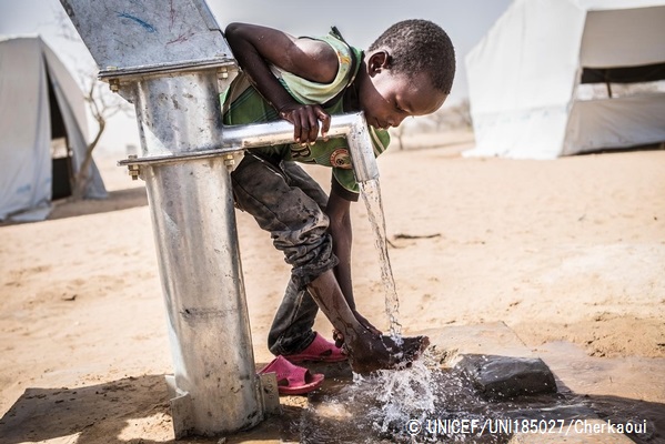 © UNICEF_UNI185027_Cherkaoui ユニセフが提供した手動ポンプで足を洗うダルエスサラーム難民キャンプで暮らす男の子。（チャド）