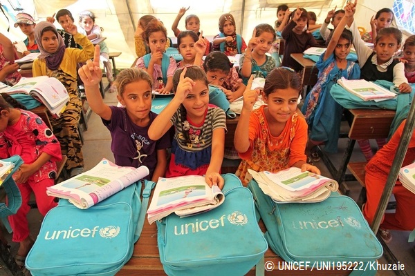 © UNICEF_UNI195222_Khuzaie ユニセフのテントの仮設学校で、夏の補習授業を実施。先生の質問に手を挙げて答える国内避難民の子どもたち。（イラク）