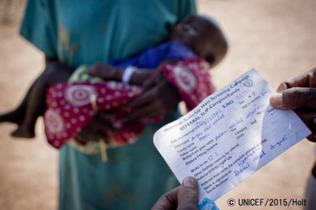 栄養不良の子どもの照会状を読む、栄養不良児の治療ケアを行うセンターの保健員。© UNICEF_2015_Holt