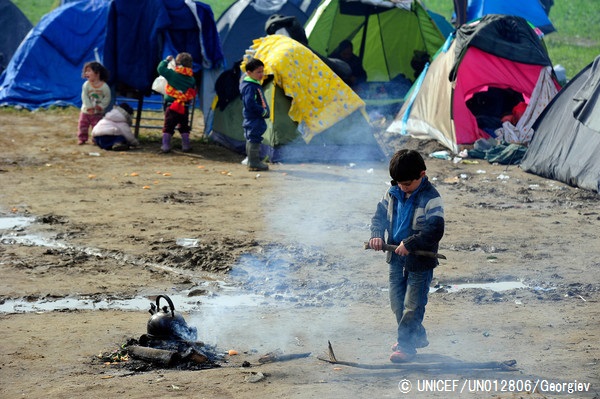テントの近くで、焚火にするために木を折る男の子。（ギリシャ）© UNICEF_UN012806_Georgiev