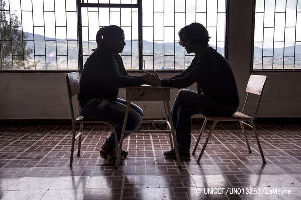 かつて武装グループと行動をともにしていた女性と話をするスタッフ。© UNICEF_UN013282_LeMoyne