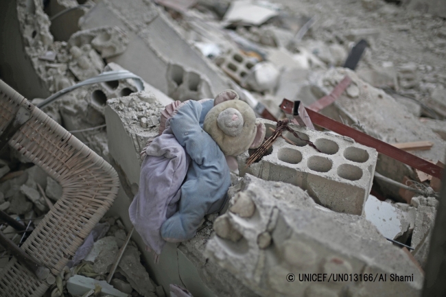 シリアの破壊された建物のがれきの間に挟まれた、子どものおもちゃ。 ※本文との直接の関係はありません。　© UNICEF_UN013166_Al Shami