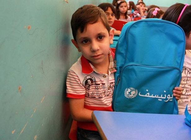 新学期にあわせて通学かばんと文房具を受け取る男の子(c) UNICEF/syria/2013/halabi