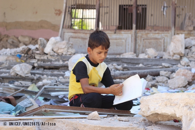 避難所として使用されている学校でノートを手にする男の子。シリア・アレッポ西部出身だが、紛争によって避難場所を転々としている (本文と直接の関係はありません）（2016年8月撮影）。