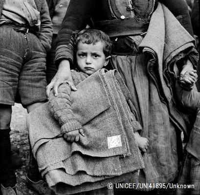 ギリシャ・カストリアにて、ユニセフより支給された毛布を抱える男の子。（1950年6月15日撮影）
