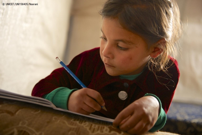 難民キャンプのテントで、宿題をする7歳の女の子。 (2013年12月撮影)