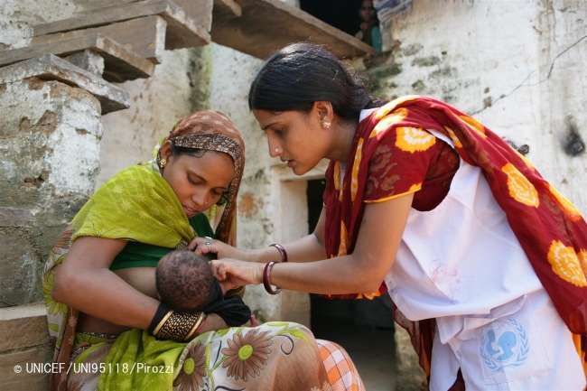 20歳の母親バビタさんが、生後15日の新生児に授乳している。ユニセフのカウンセラー（写真右）は、各家庭をまわり、正しい母乳育児の方法について伝えている。（インド）© UNICEF_UNI95118_Pirozzi