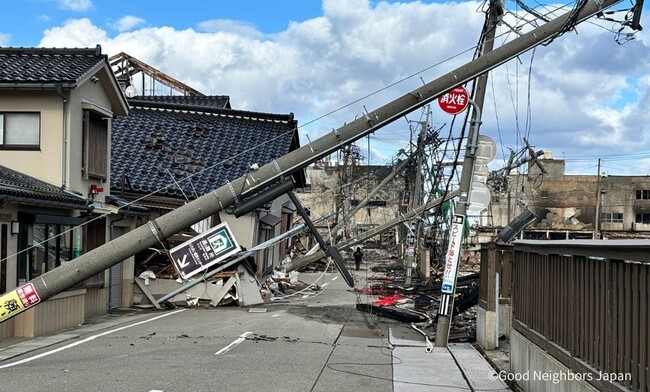 地震により倒れる電信柱と倒壊した家屋、さらに火事の跡も残る（2024年1月4日、石川県輪島市）