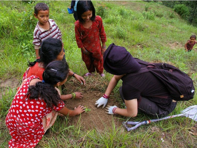 ネパールで現地の子どもたちと植林をする最高学部生。