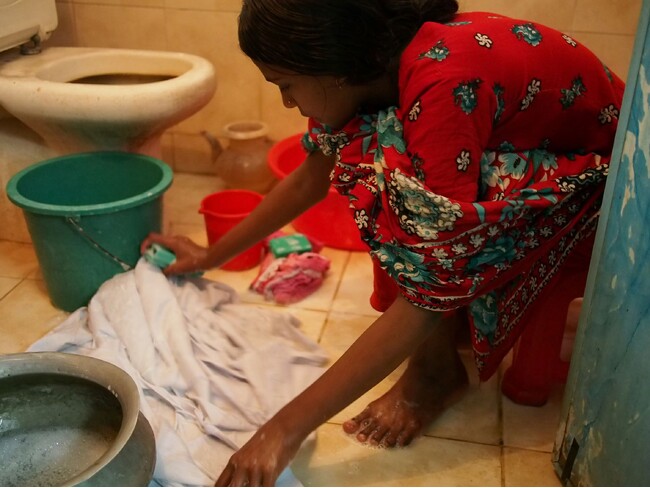 バングラデシュで家事使用人として働く少女。洗濯をしている様子
