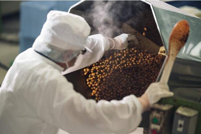冨士屋製菓本舗の豆菓子を作る際の味付けで醤油をかける作業の様子 冨士屋製菓本舗の豆菓子を作る際の味付けで醤油をかける作業の様子