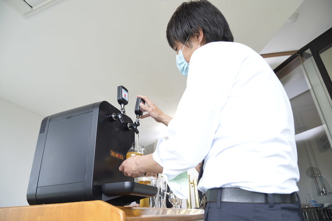 ご自身でビールを注ぎ、そのコンディションを確認する工場長の戸塚正城さん。