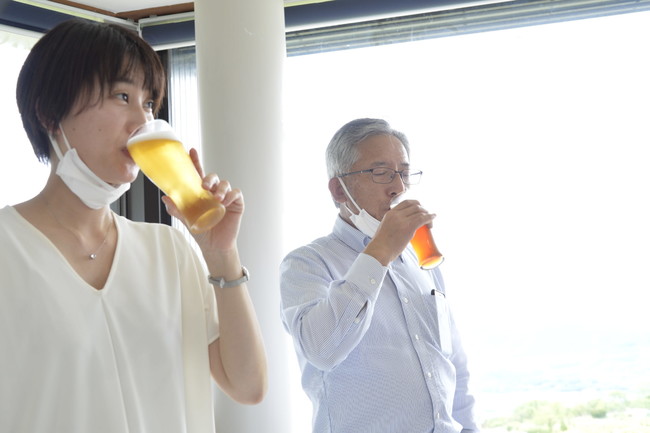 サーバーから注がれたビールを飲んで、そのコンディションを確認する高玉さん（左）と小林亮二さん。