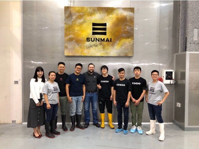 2019年11月コラボレーション時の写真。台湾のSUNMAIブルワリーにて。（中央左が醸造担当者のクリスと肩を組むCOEDO似内（醸造担当者）