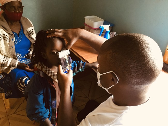 Smart Eye Cameraを使ってケニア農村部の子供の診断を行うKisii Eye Hospitalのスタッフ