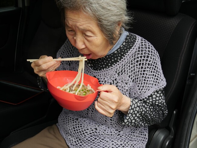 うどん鉢でうどんを食べるおばあちゃん