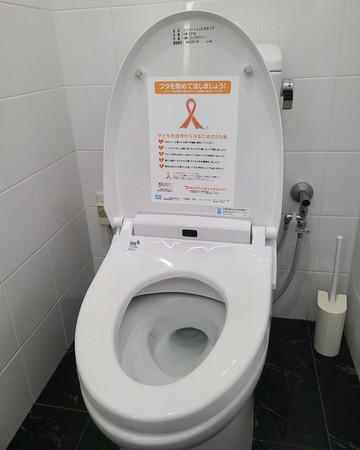 オレンジリボン運動アドレットを貼付したトイレ