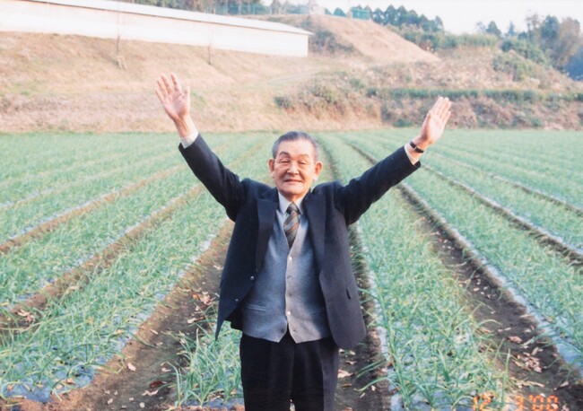 ▲にんにく畑の前に立つ創業者・本多荘輔