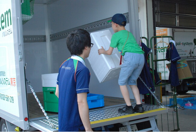 ▲配送職員と一緒に「おしごと体験」（2019年度開催時撮影）