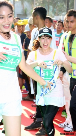 第2走者JKT48アリシア・チャンジアさん（左）がAKB48の第3走者・平田梨奈さんにタスキをつなぐ