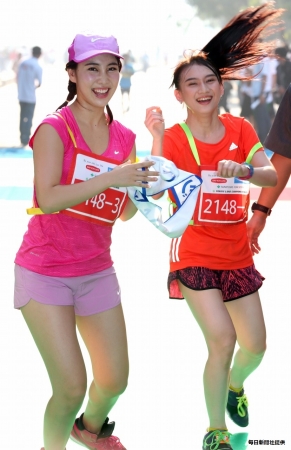 JKT48のチーム第2走者・メロディーさん（右）から第3走者の近野莉奈さんに