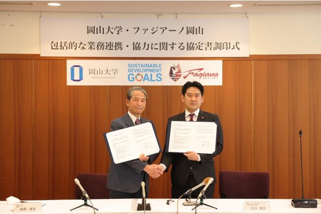 協定書を手に固く握手を交わす北川社長(右)と槇野学長 協定書を手に固く握手を交わす北川社長(右)と槇野学長