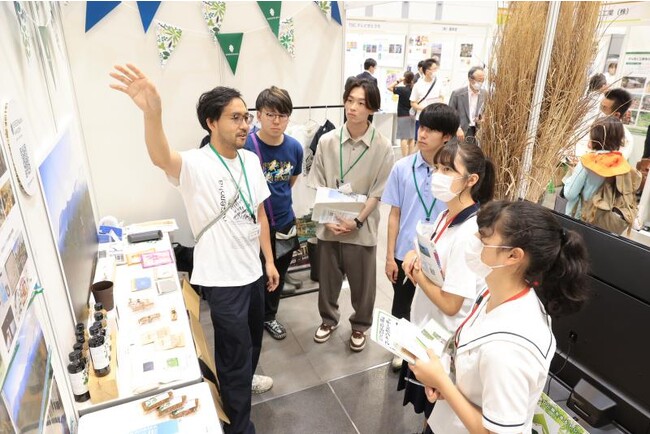 スタディツアーで企業の取り組みについて説明を聞く高校生ら