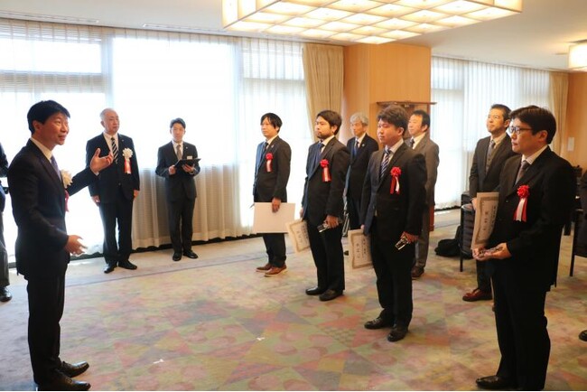 伊原木知事（左）からお祝いの言葉をかけられる受賞者（岡山県教育庁提供）