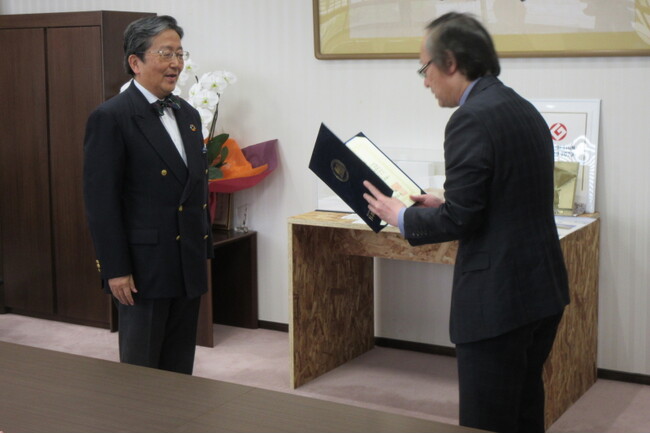 那須学長（左）から感謝状を受け取る久保田教授