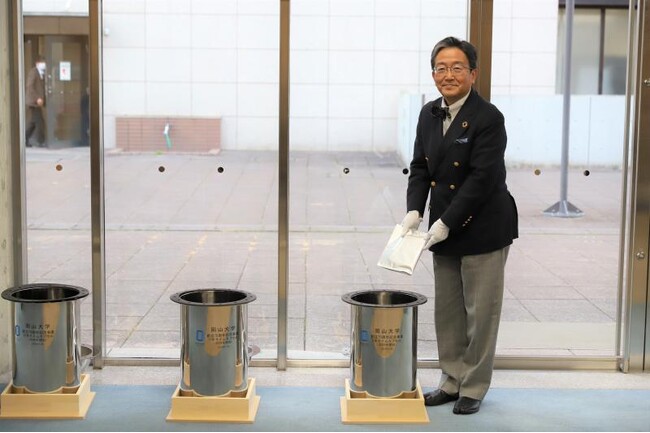 タイムカプセルにハガキを封入する那須学長