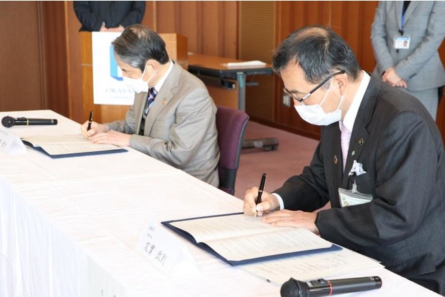 協定書に署名する槇野学長(左)と友實市長 協定書に署名する槇野学長(左)と友實市長